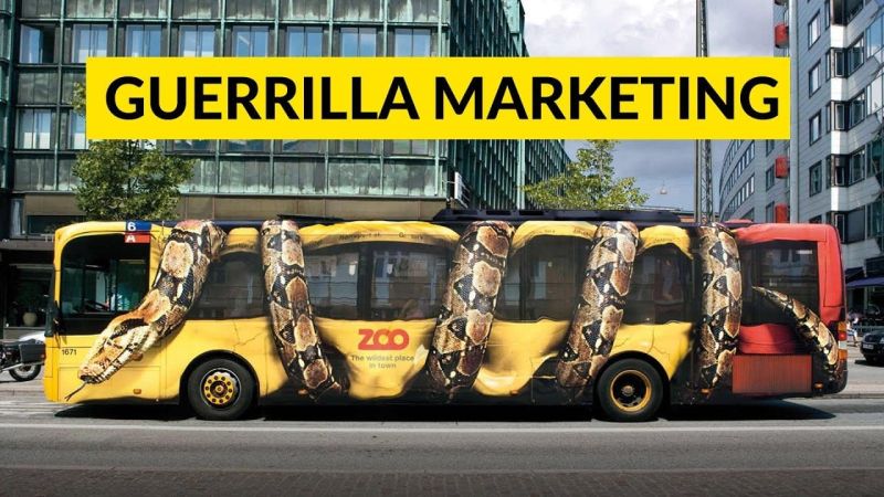 Yellow city bus wrapped as a giant coiled snake advertising a zoo, under a yellow guerrilla marketing banner.