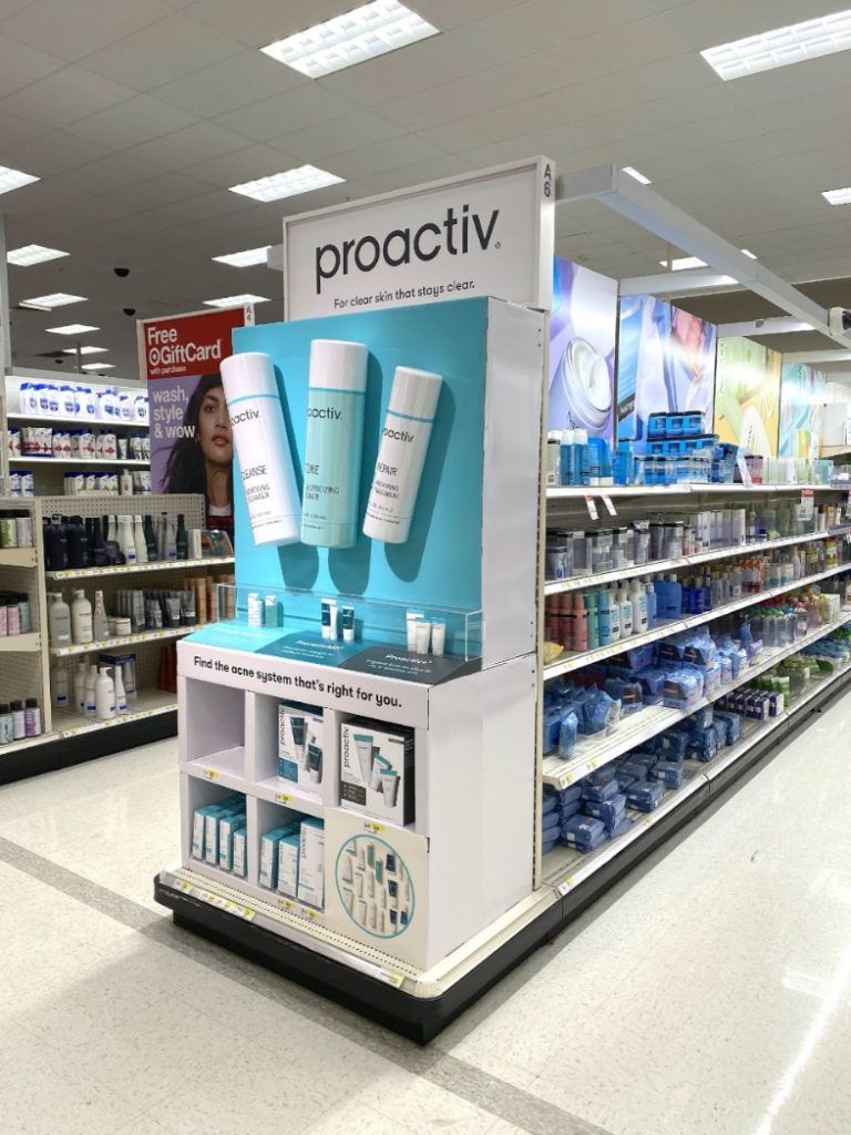 Proactiv skincare endcap display with large bottle props at the end of a store aisle.