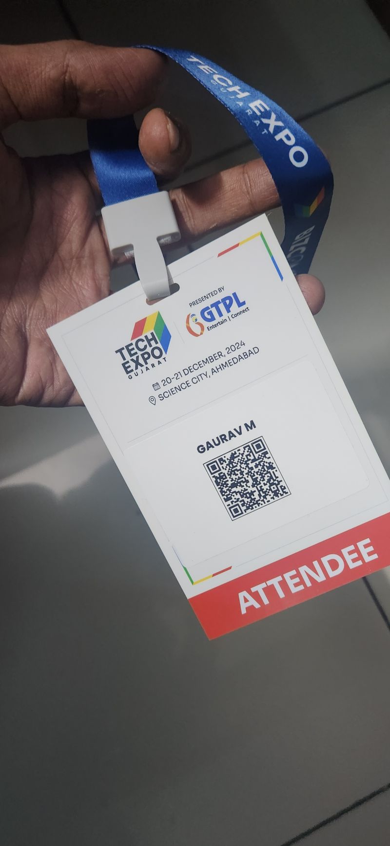 A hand holds a Tech Expo Gujarat attendee badge issued to Gaurav M for 20-21 December 2024 at Science City, Ahmedabad.
