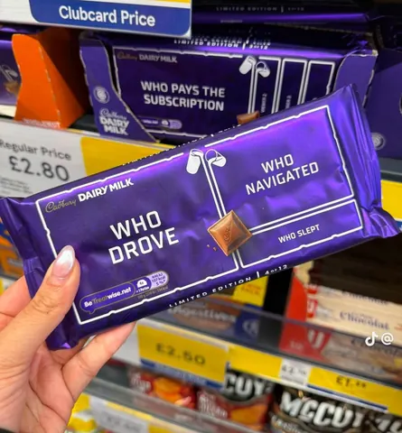 Hand holding a Cadbury Dairy Milk limited edition bar split into Who Drove, Who Navigated and Who Slept.