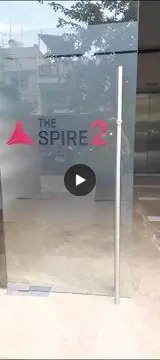 Frosted glass door bearing The Spire 2 logo with a red triangle, marking an office entrance.