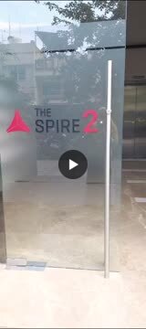 Frosted glass door bearing The Spire 2 logo with a red triangle, marking an office entrance.