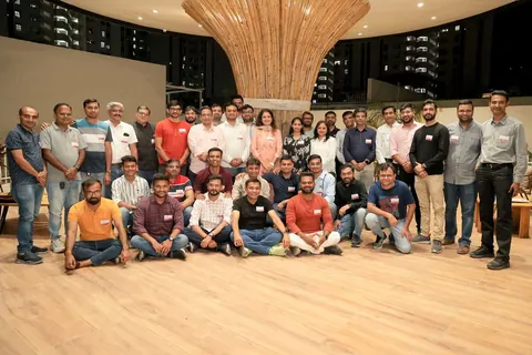 A large group of attendees posing together at an evening venue during the SaaSBoomi Social in Rajkot.