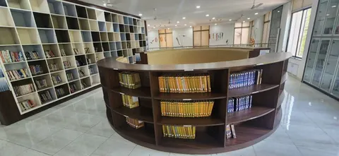 Curved wooden shelf of books in a bright hall lined with white cubby shelves of books