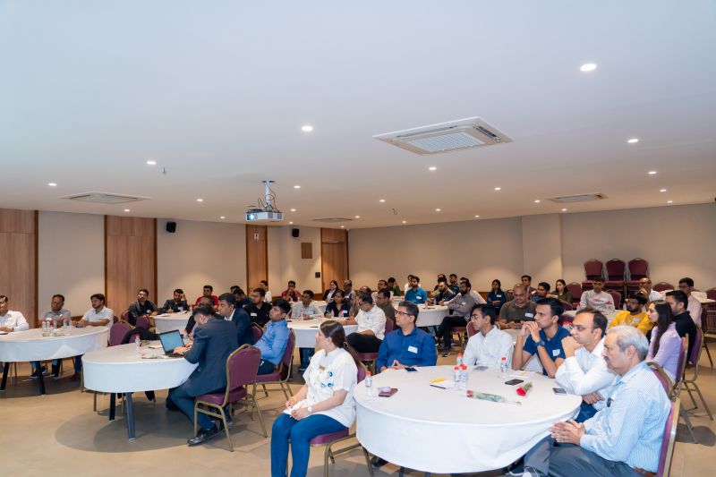 Attendees seated at round tables fill a conference room during a seminar session.