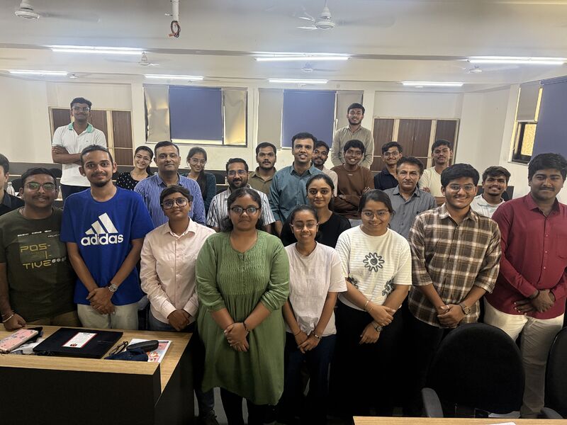 Students and mentors pose together for a group photo in a classroom.