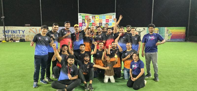 A large group of players with medals and trophies cheer together on the turf at Infinity Sports Club.