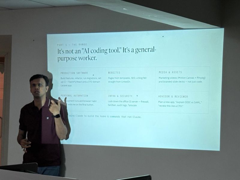 Gaurav stands beside a projected slide calling Claude Code a general-purpose worker, not just a coding tool.